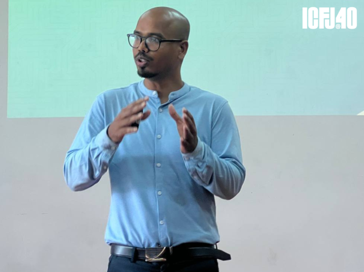 A photo of Bharat Nayak presenting in front of a screen.