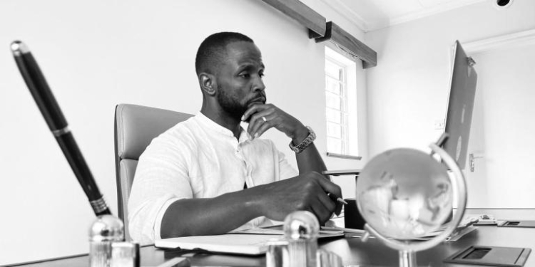 A photo of John-Allan Namu working at a desk.