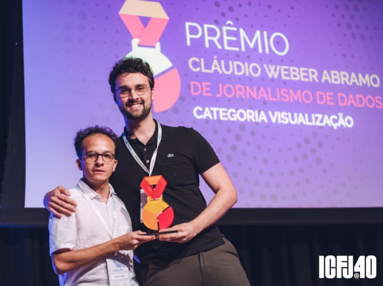 A photograph of Gabriel Zanlorenssi accepting a trophy with another man. 