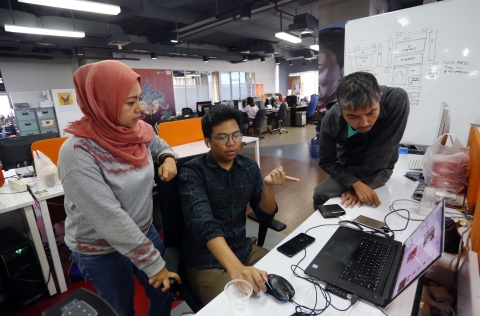 Three journalists at computer