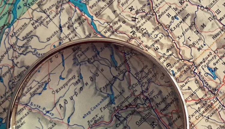 A close-up photo of a magnifying glass on top of a map. 